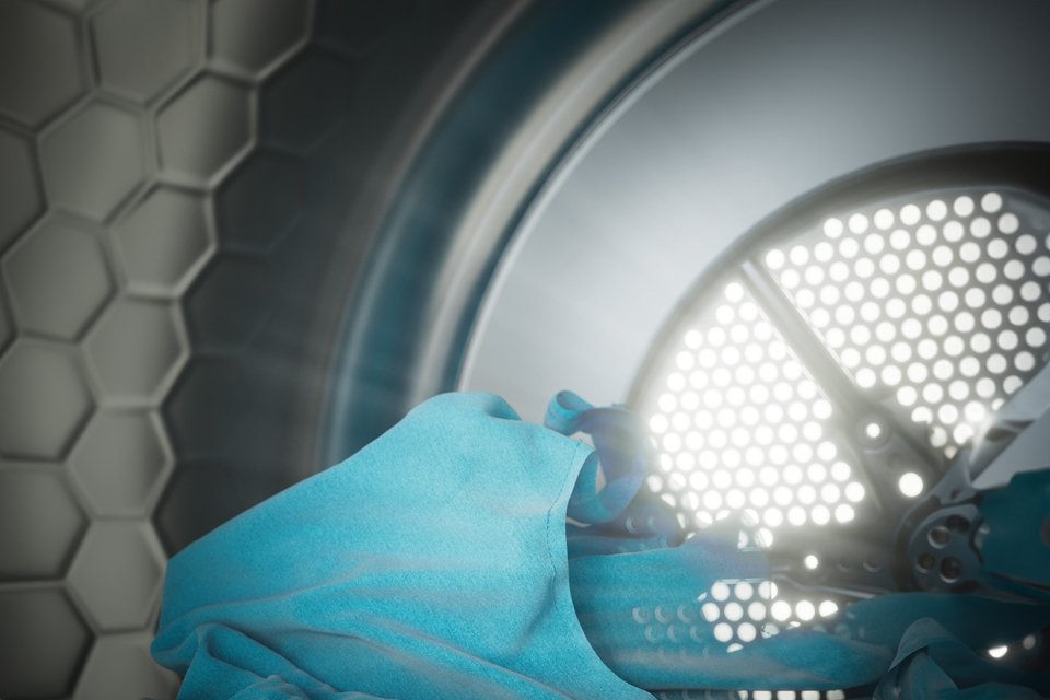 The inside of the Miele tumble dryer with blue fabric being dried.